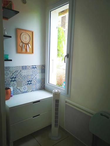 La salle de bains est pourvue d'une fenêtre et d'un radiateur. dans l'établissement Le Studio Charmant à 20min de Paris, à Villennes-sur-Seine