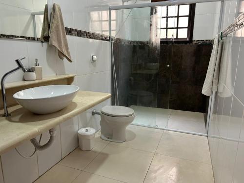 een badkamer met een wastafel, een toilet en een douche bij Cantinho da serra in Ubatuba