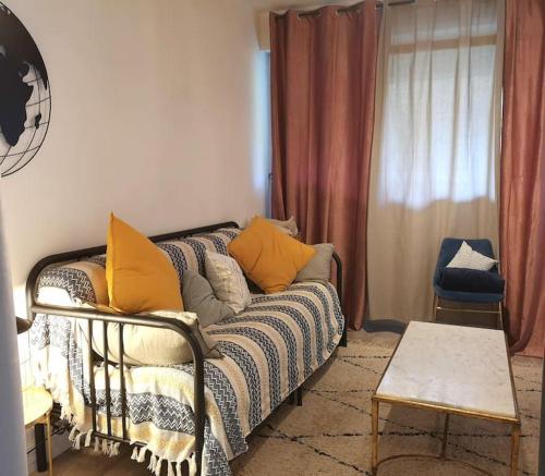 - un salon avec un canapé et des oreillers jaunes dans l'établissement Mon Studio en bordure de forêt, Golf St-Germain, à Poissy