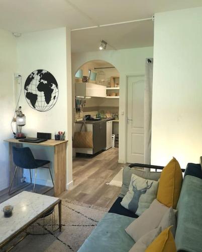 un salon avec un canapé et une table dans l'établissement Mon Studio en bordure de forêt, Golf St-Germain, à Poissy