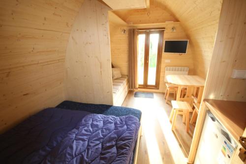 a small room with a bed and a dining room at Camping De Grienduil in Nieuwland