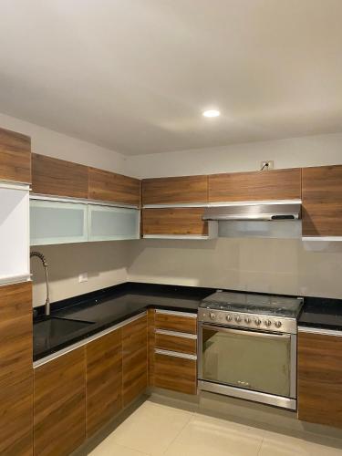 a kitchen with wooden cabinets and a stove at Departamento en zona Angelopolis in Puebla