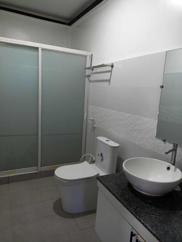 a bathroom with a toilet and a sink at Elpo's House in Panabo