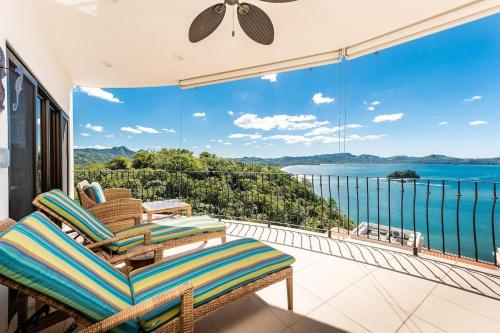 a balcony with chairs and a view of the ocean at Oceanfront Infinity Pool and Sunset Veranda in Playa Flamingo