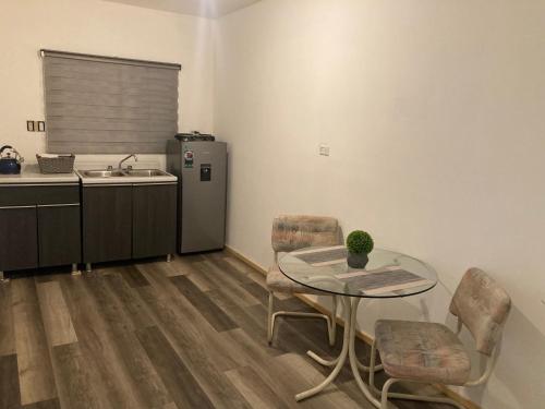 a kitchen with a table and chairs and a refrigerator at Departamento amplio y tranquilo in Mexicali