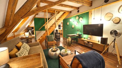 a living room with a couch and a flat screen tv at Green Loft Schwarzwald - Dach-Balkon--Musik-Ecke in Winzeln