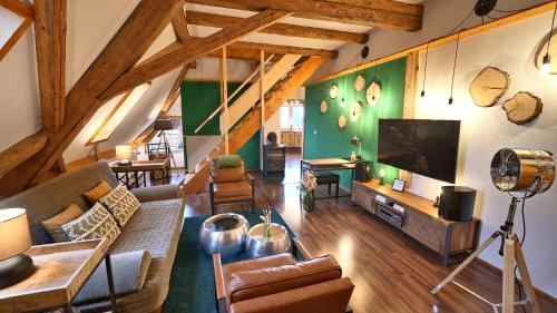 a living room with a couch and a flat screen tv at Green Loft Schwarzwald - Dach-Balkon--Musik-Ecke in Winzeln