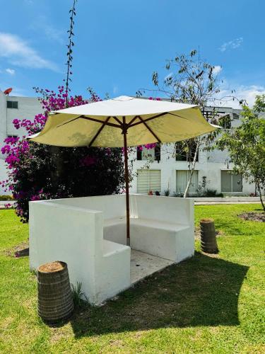 a table and an umbrella sitting in a yard at Apartamento en Villa Toscana en Boyaca in Ramiriquí