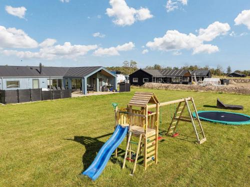 a playground in a yard with a slide and a slideintend at Luxury Retreat in albaek - By Traum Ferienwohnungen in Ålbæk