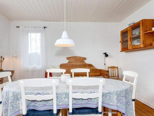 a white dining room with a table and chairs at 6 person holiday home in Ålbæk-By Traum in Ålbæk