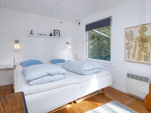 a bedroom with white walls and a bed with blue pillows at 6 person holiday home in Tarm-By Traum in Tarm