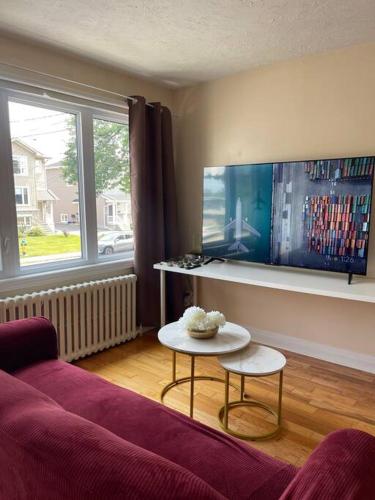 a living room with a purple couch and a table at Entire Apartment in Kingston