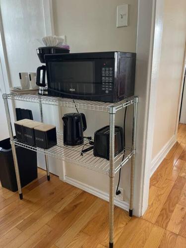 a microwave on a metal shelf with a microwave at Entire Apartment in Kingston