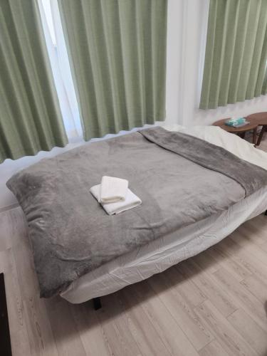a bed with two towels on it in a bedroom at JR Shin-Osaka 30s, Direct to Kansai Airport 關西空港直達,Shinkansen to Tokyo, Tokyo & Nagoya, Universal Studio 16 mins, Umeda 6 mins, Kyoto 25 mins, Early Check-In in Osaka