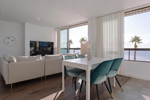 ein Wohnzimmer mit einem weißen Tisch und Stühlen in der Unterkunft Antic Rooms Varadero in Villajoyosa