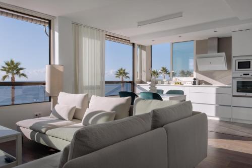 ein Wohnzimmer mit 2 Sofas und einer Küche in der Unterkunft Antic Rooms Varadero in Villajoyosa