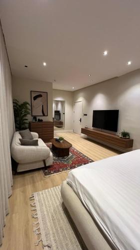 a bedroom with a bed and a flat screen tv at Elegant studio - COZY apt in Riyadh