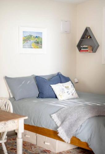 a bedroom with a bed with blue pillows on it at One77 Rural Retreat in Matarawa