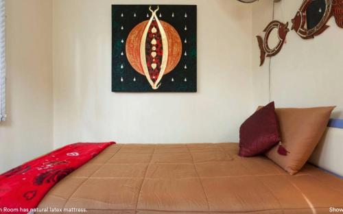 a bed in a room with a painting on the wall at HomeSweetHome in Hang Dong