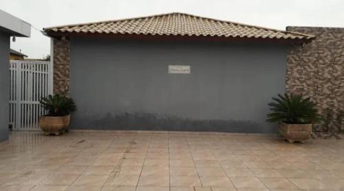 a garage with two potted plants in front of it at casa itanhaém in Itanhaém