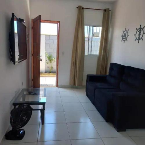 a living room with a blue couch and a table at casa itanhaém in Itanhaém
