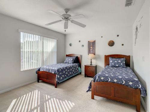 a bedroom with two beds and a ceiling fan at Charming & Cozy Getaway! Lazy River! in Davenport