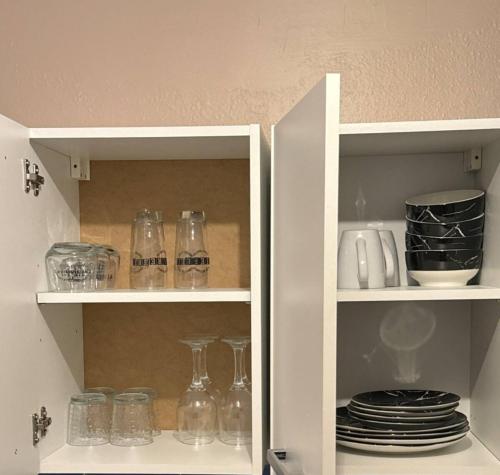 une armoire blanche avec des verres et de la vaisselle dans l'établissement Claire joie, à Bourges