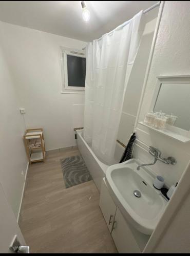 une salle de bain blanche avec un lavabo et une baignoire dans l'établissement Claire joie, à Bourges