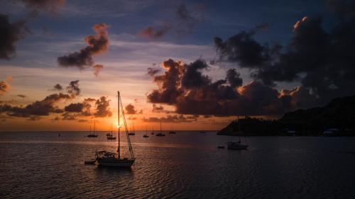 a group of boats in the water at sunset at South West Bay Cabañas in Providencia