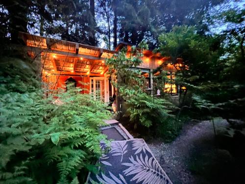 a house with lights in the middle of a garden at Sojourn Rustic Spa Retreat in Point Roberts