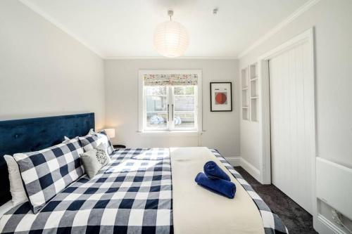 a bedroom with a bed with a blue pillow on it at Cologne Cottage in Martinborough 