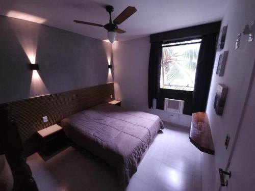 a bedroom with a bed and a window at Riviera de São Lourenço Apto Completo com Churrasqueira Serviço de Praia Piscina aquecida Sauna salão de jogos e quadra in Riviera de São Lourenço