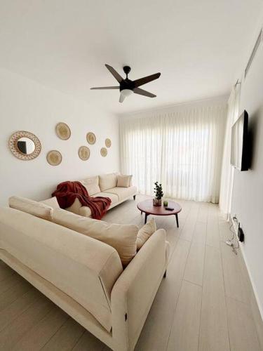 a living room with a couch and a ceiling fan at Corals Retreat 2BR Beach Condo in Punta Cana