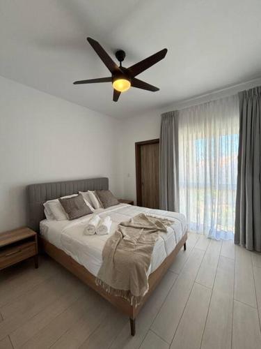 a bedroom with a bed with a ceiling fan at Corals Retreat 2BR Beach Condo in Punta Cana