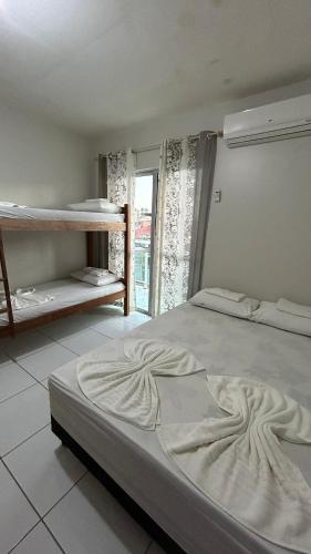 a bedroom with a large bed and a window at Flats Duplex Super Aconchegantes e Confortáveis in Maragogi