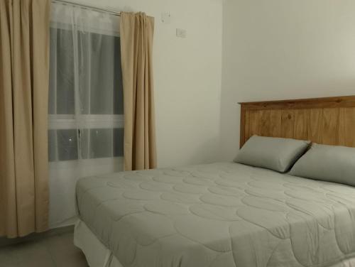 a bedroom with a bed and a window with curtains at Departamento céntrico zona clínicas MIT - Nefrología in Santa Fe