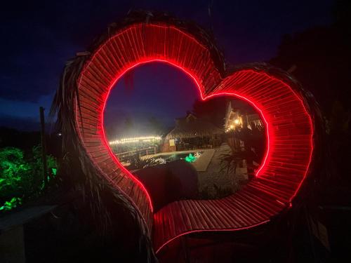 a red heart shaped lighted sign at night at finca campestre las heliconias in Puerto Triunfo