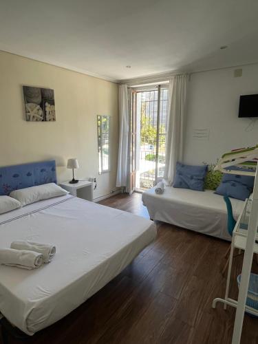 een slaapkamer met twee bedden en een raam bij El Parterre Apartamento in Valencia