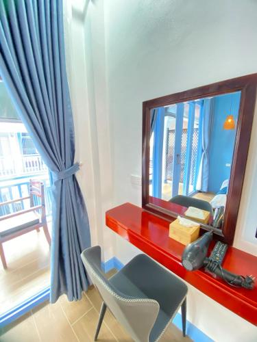 a mirror and a chair in a room at Sadakham Royal View Hotel in Luang Prabang