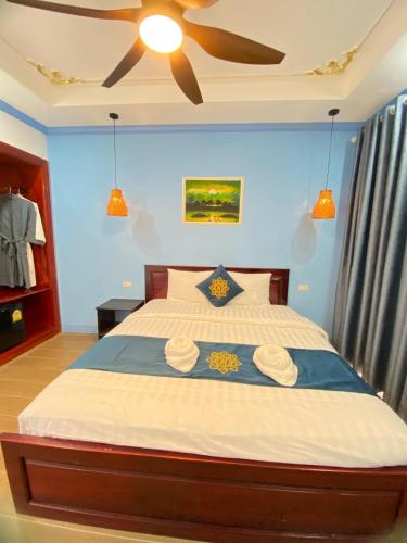 a bedroom with a large bed with a ceiling fan at Sadakham Royal View Hotel in Luang Prabang