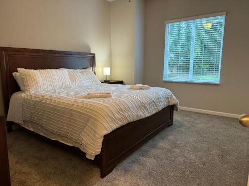 Un dormitorio con una cama grande con ventana. en 2 Bedroom Townhouse 2024 New Construction, en Charlotte
