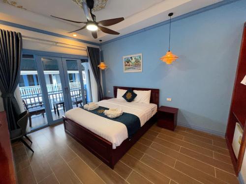 a bedroom with a bed and a ceiling fan at Sadakham Royal View Hotel in Luang Prabang