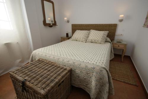 a small bedroom with a bed and a mirror at Finca El Romeral in Alpera