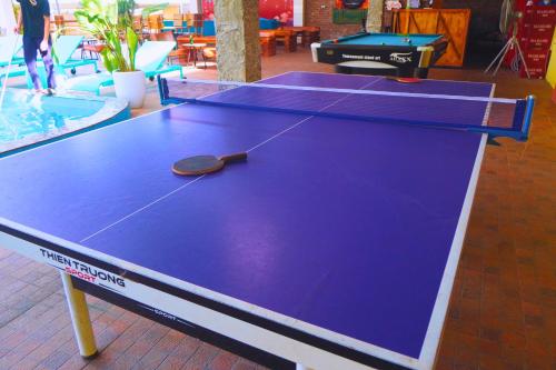a ping pong table with a paddle on top of it at Ha Giang Loop Rabbit Hostel & Tours in Ha Giang