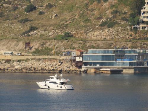 a white boat in the water next to a building at La Tourelle in Jounieh