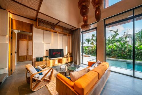 a living room with a couch and a tv at TUI BLUE Berawa Hotel and Villas in Canggu