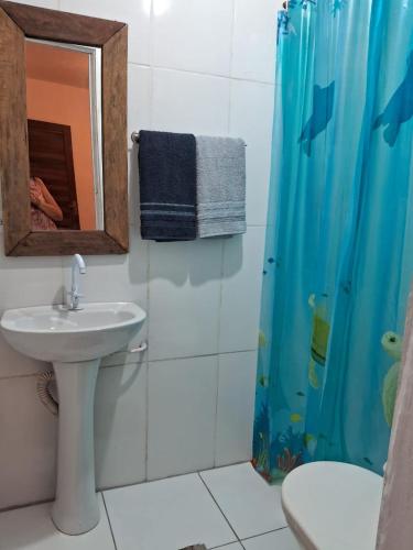 a bathroom with a sink and a shower curtain at Espaço Odara Suites com cozinha compatilhada in Paraty