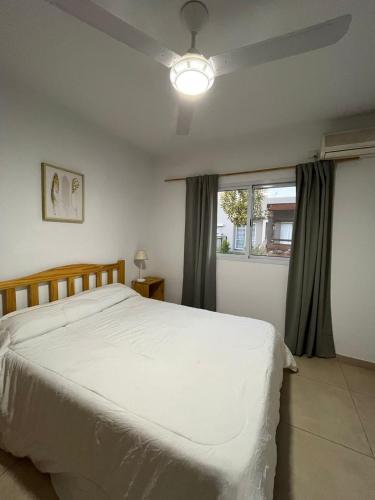a bedroom with a white bed and a window at El Remanso in San José