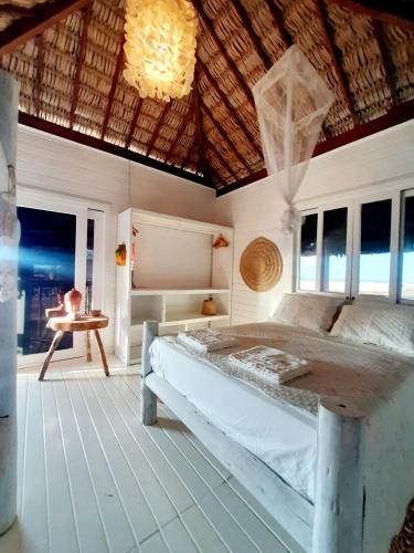 a bedroom with a bed and a table in it at Vila Ascensão in Tatajuba