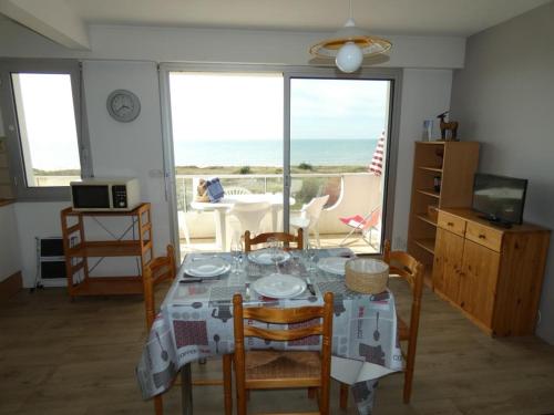 une salle à manger avec une table et des chaises avec vue sur l'océan dans l'établissement Appartement pour 6 personnes à 10m des plages, animaux acceptés, parking - FR-1-540-244, à Notre-Dame-de-Monts